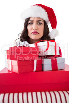 Confused brunette holding pile of gifts