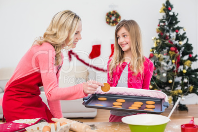 Festive mother and daughter making christmas cookies