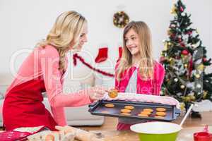 Festive mother and daughter making christmas cookies