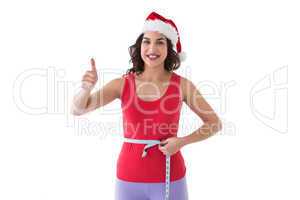 Festive fit brunette measuring her waist