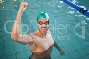Portrait of a fit swimmer cheering in the pool
