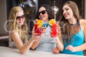 Attractive friends drinking cocktails together