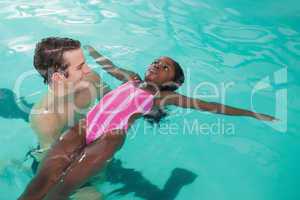 Cute little girl learning to swim with coach