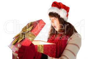 Shocked festive brunette opening a gift