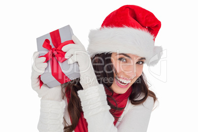 Happy brunette in santa hat holding gift