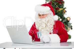 Father christmas shopping online with laptop