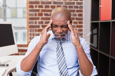 Businessman with severe headache in office
