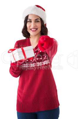 Happy brunette in santa hat offering gift