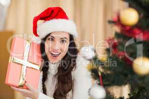 Surprised brunette holding a gift