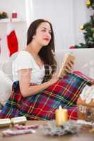 Interested brunette reading on the couch  with cover