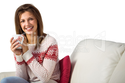 Pretty brunette enjoying a hot drink on the couch