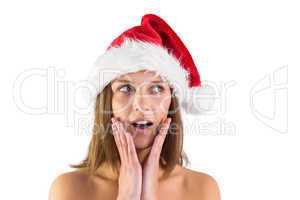 Festive brunette looking surprised with hands on face