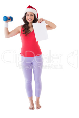 Festive athletic brunette holding page and dumbbell
