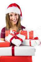 Smiling brunette in santa hat holding pile of gifts