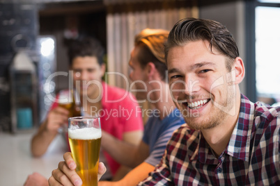 Young man holding pint of beer