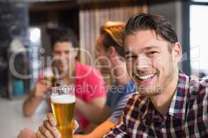 Young man holding pint of beer