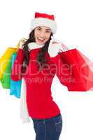 Festive brunette in winter wear holding shopping bags