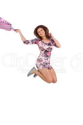Excited brunette jumping while holding shopping bag