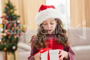 Festive little girl opening a gift