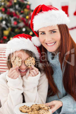 Festive mother and daughter on the couch with cookies