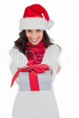 Festive brunette in santa hat giving gift