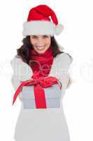 Festive brunette in santa hat giving gift