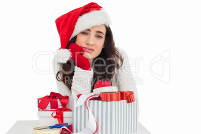 Unsure brunette in santa hat packing gifts