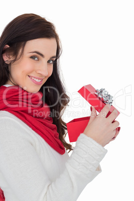 Smiling brunette opening christmas present