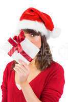 Festive woman looking at camera holding a gift