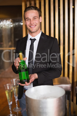 Handsome man showing champagne bottle