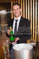 Handsome man showing champagne bottle