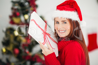 Festive redhead holding christmas gift