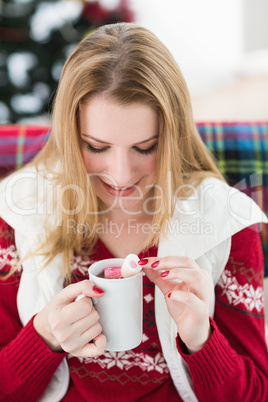 Happy blonde in winter clothes holding mug