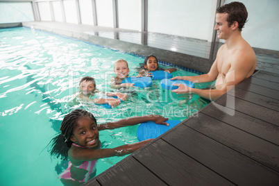 Cute swimming class in pool with coach