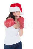 Festive brunette in boxing gloves punching