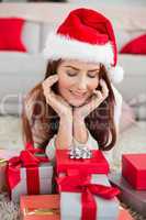 Festive redhead smiling at gifts