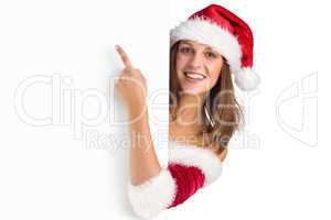 Pretty girl in santa costume showing card