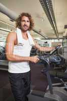 Man standing by exercise bike at gym