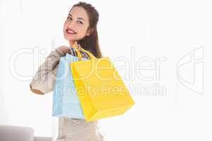 Happy brunette holding shopping bags