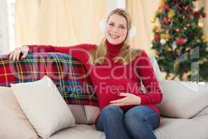 Beautiful pregnant woman sitting on a couch