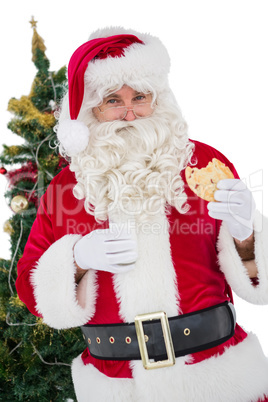 Cheerful santa eating a cookie