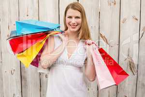 Smiling woman carrying shopping bags over her shoulder