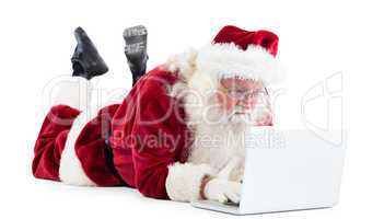 Santa lies in front of his laptop