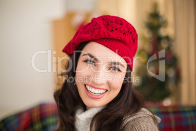 Portrait of a smiling brunette in hat at christmas