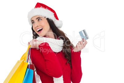 Festive brunette holding shopping bags and credit card