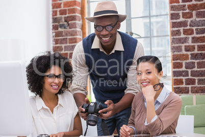 Portrait of photo editors with camera in office