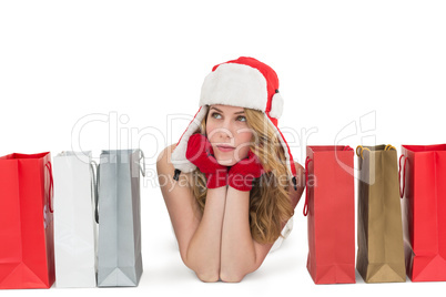 Thoughtful woman lying between shopping bags