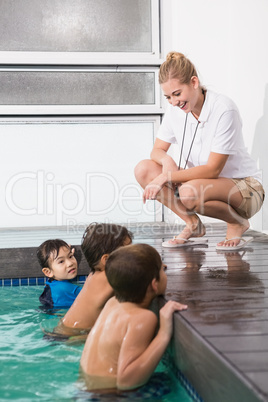 Cute kids in the swimming pool listening to coach
