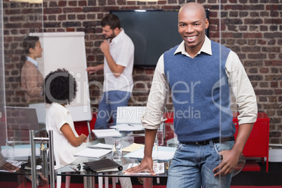 Smiling young businessman with colleagues in background