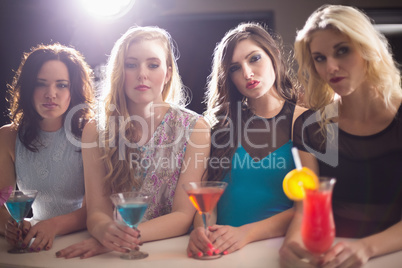 Attractive friends drinking cocktails together
